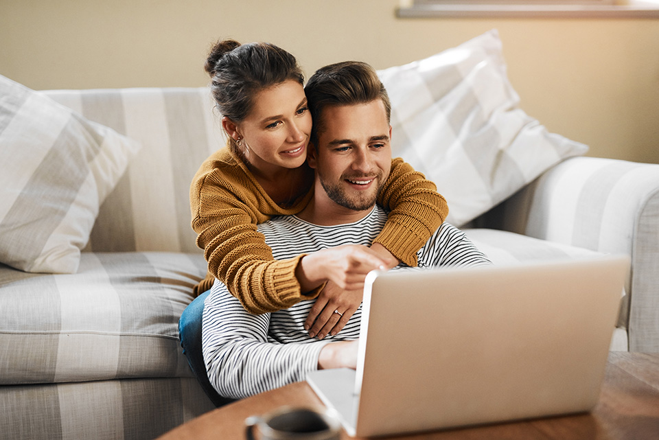 O femeie și un bărbat care verifică ceva pe laptop